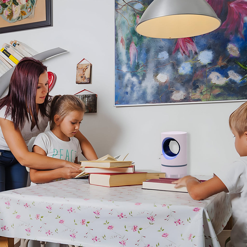 Family using Electric Mosquito Zapper at a table while reading books in a cozy home environment.