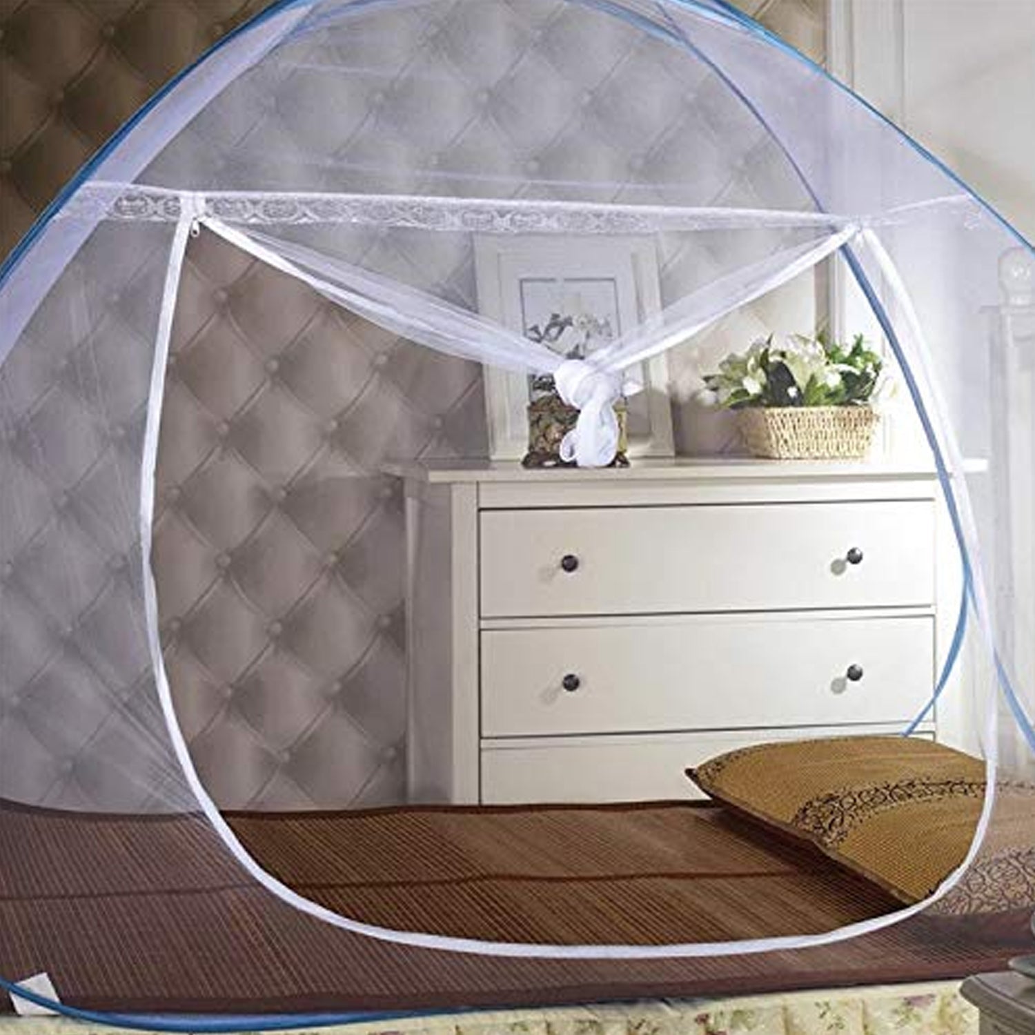 Pop-up mosquito net set up on a bed in a bedroom.